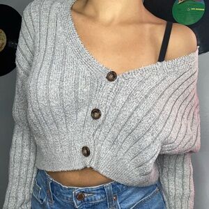 Gray knit sweater that hangs off the shoulder from garage. Pre loved